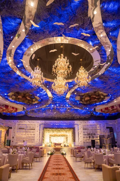 Home 8 Windsor Hall grand ballroom with crystal chandeliers and blue draped ceiling at Mallu Farms, Chattarpur